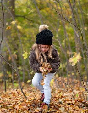 Pige leger i den smukke efterårs skov